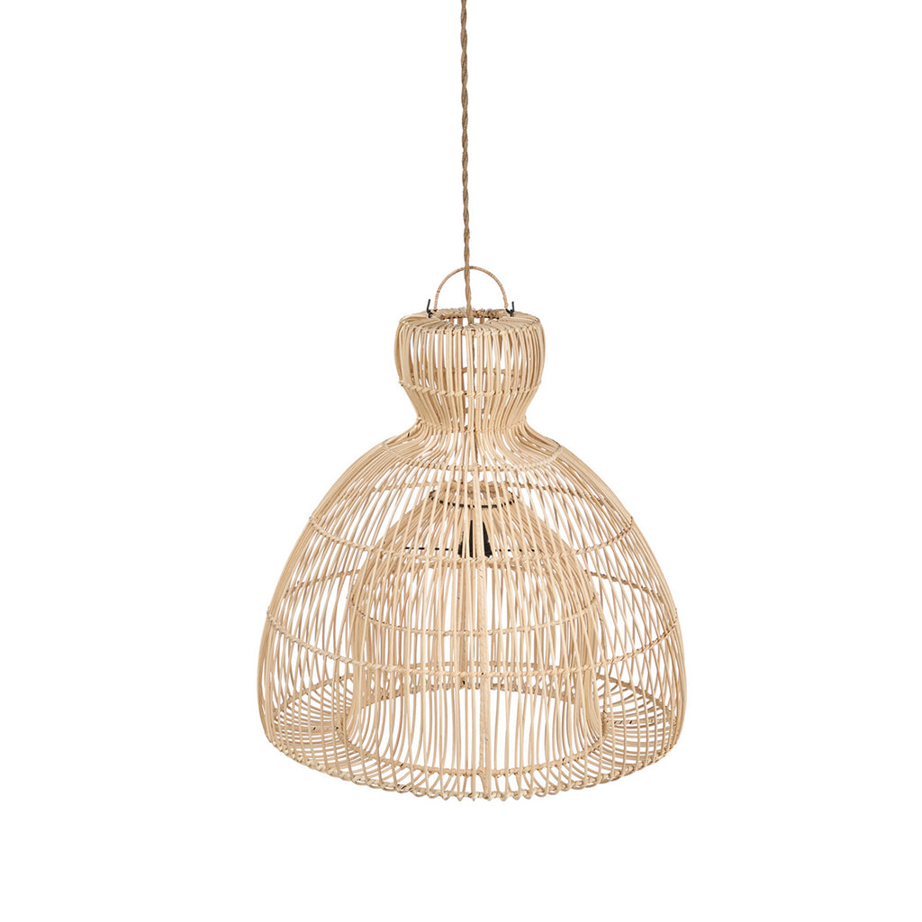 A woven rattan pendant light with a warm glowing bulb, hanging in a cozy, sunlit room with a beige sofa, textured pillows, and a potted olive tree.