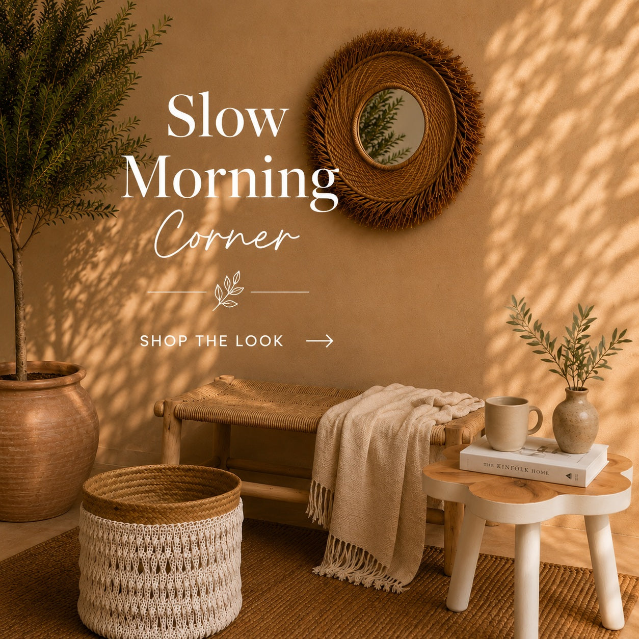 A Bali style interior scene with warm sunlight and leaf shadows across a beige wall, featuring a woven round mirror, a bench, a throw blanket, a small side table with books and a mug, a woven pouf, and a potted plant. Large overlaid text reads 'Slow Morning Corner' with 'SHOP THE LOOK' below.