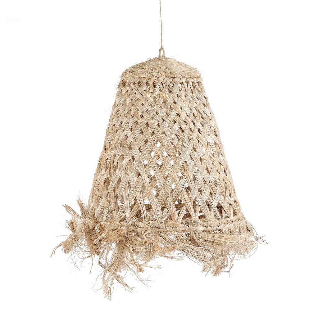 A woven natural-fiber pendant light hangs in a rustic, sunlit room with a cream sofa, textured pillows, a wooden coffee table, and an arched doorway leading to an outdoor garden.