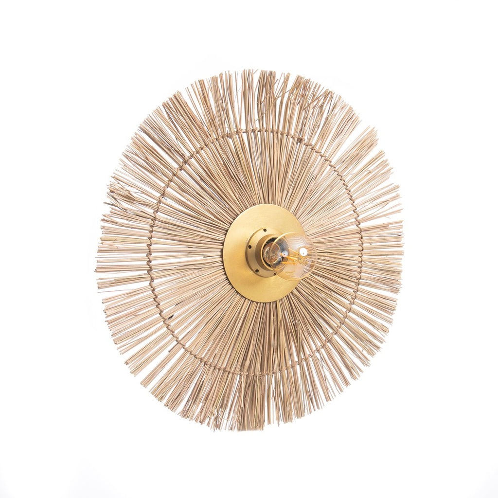 Round rattan woven wall art piece with a central light fixture on a white background
