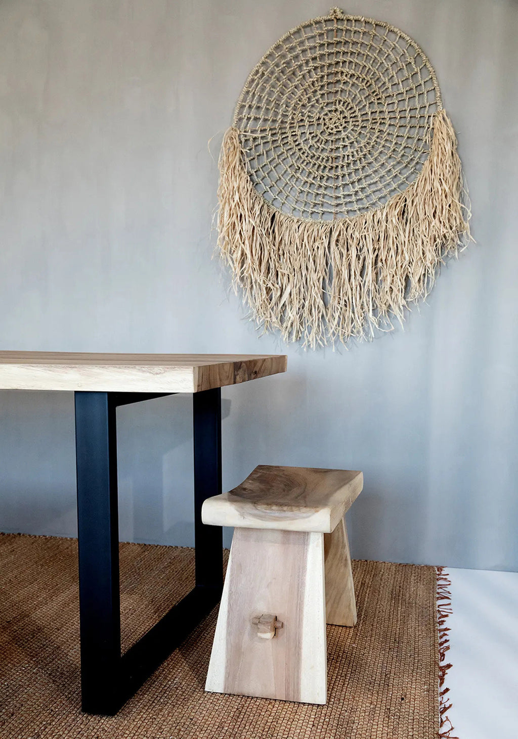 Natural fibre woven rug with fringes on a white background