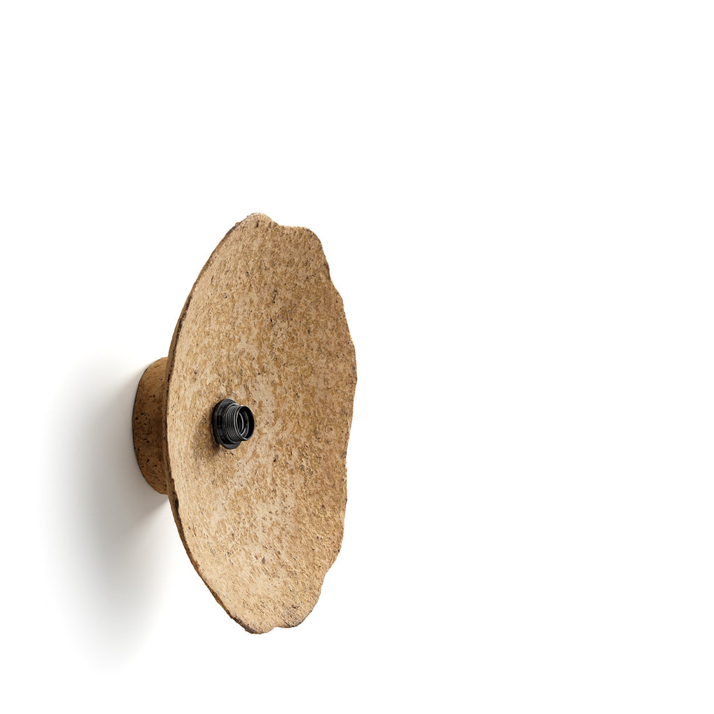 Decorative wall light fixture with a textured beige finish on a white background