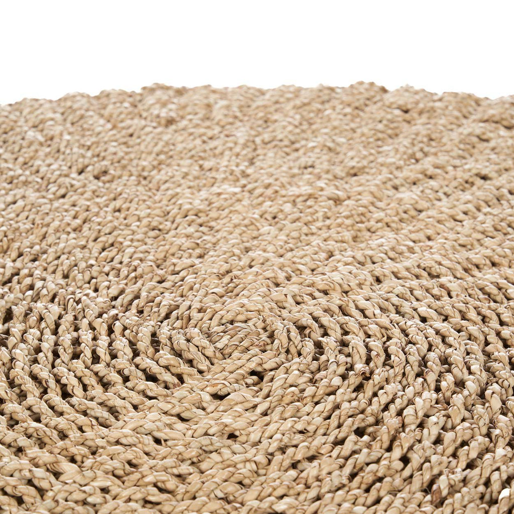 Round hand woven round rug on a white background