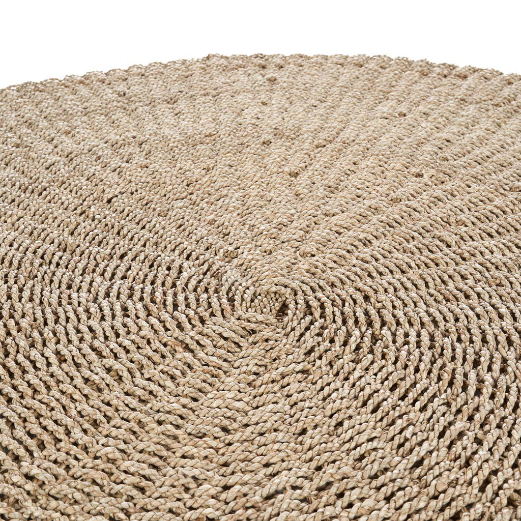 Round woven by hand rug on a white background